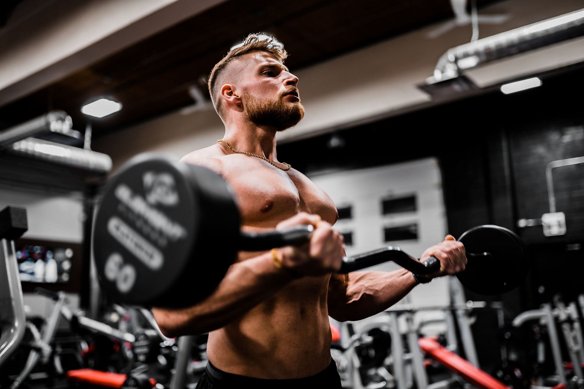 Bicep curls are a great way to build strong arms. (Image via Unsplash/Anastase Maragos)